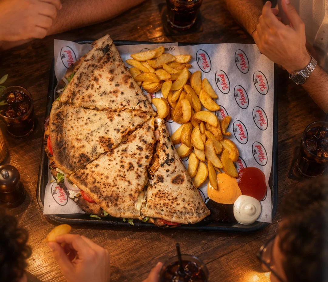 Des amis autour d'un plateau de makloubs et de potatoes